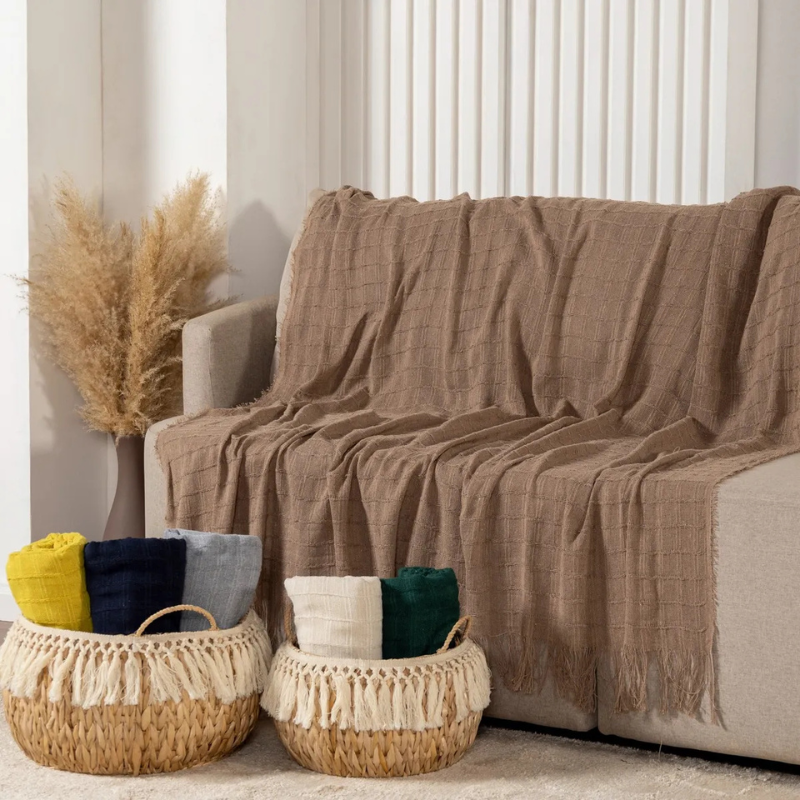 Manta xale para sofá em tom neutro usada na decoração da sala
