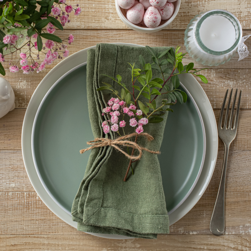 Mesa posta elegante com prato verde e guardanapo de tecido decorado