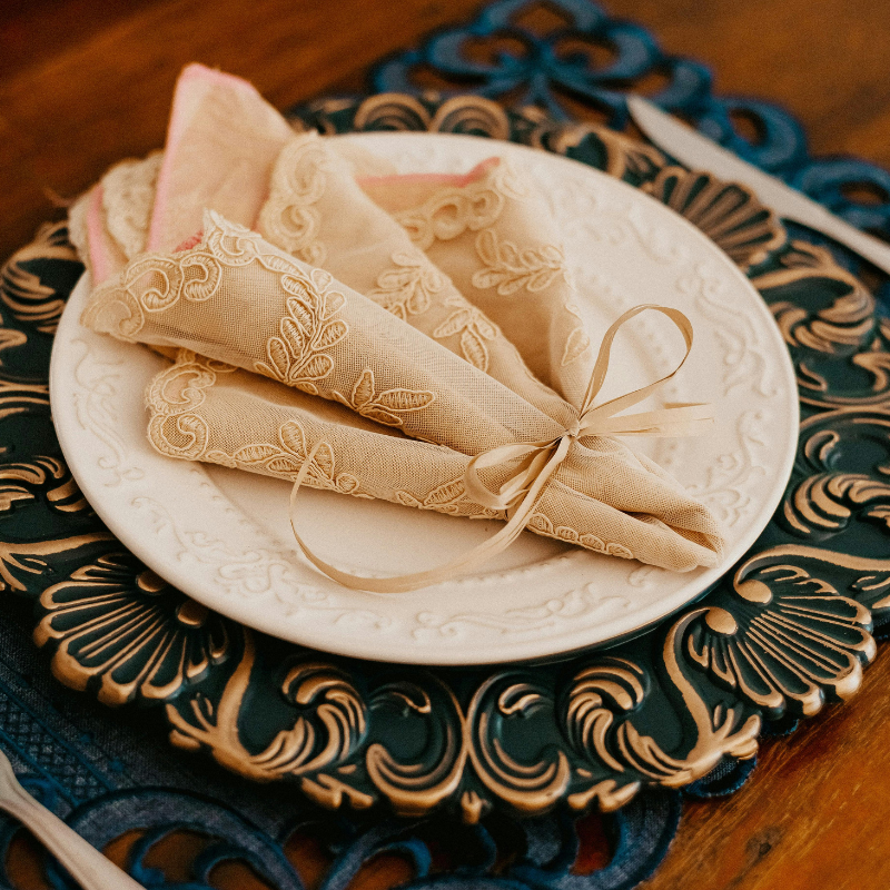 Mesa posta sofisticada com sousplat azul ornamental e guardanapo de tecido bege