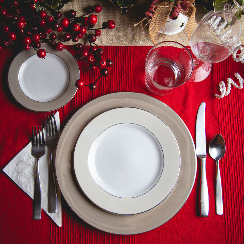 Mesa posta de Natal com toalha vermelha e louça branca elegante