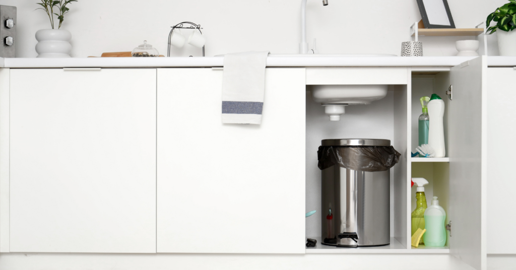 lixeira dentro do armário da pia em cozinha organizada