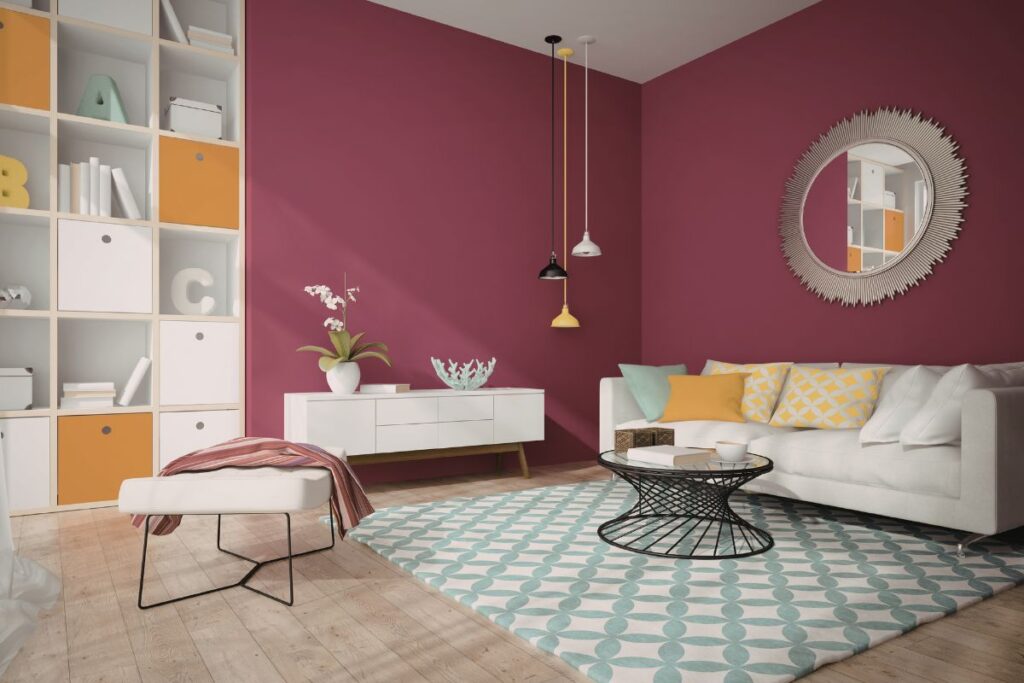 Espelho redondo decorando sala de estar moderna com parede vinho e sofá claro