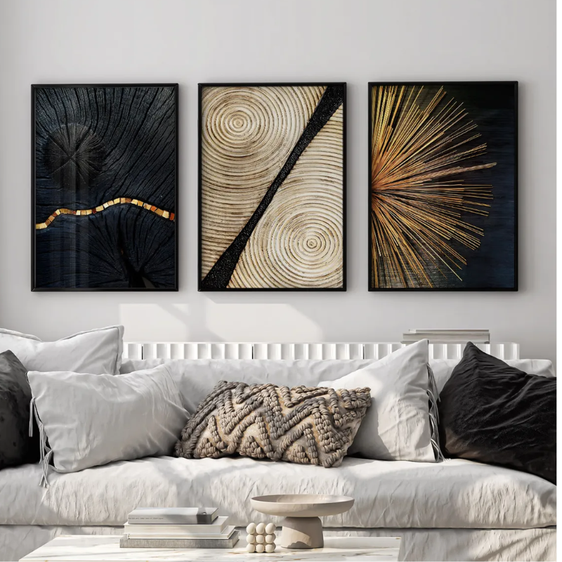 conjunto de quadros abstratos preto e dourado decorando parede de sala moderna com sofa claro