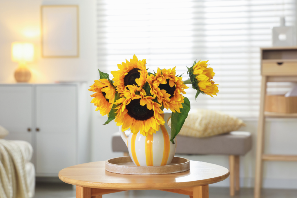 Vaso com girassóis sobre mesa de centro em sala de estar iluminada